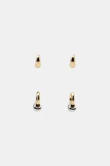 Pack de cuatro pendientes tipo aro. Dos son aros lisos dorados con cierre de clip. Los otros dos son aros dorados con un dije colgante esférico bicolor (dorado y plateado) con cierre de clip.