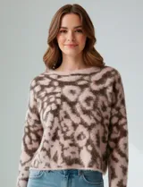 Buzo de lana con diseño de animal print en tonos rosado y marrón oscuro. Es de corte crop, manga larga amplia y cuello redondo.