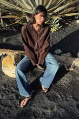 Sobrecamisa de tejido efecto ante en color marrón, con cuello solapa, manga larga con puños y cierre frontal de botones. Presenta un bolsillo de plastrón en el pecho.