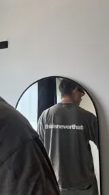 Remera gris oscura de algodón con corte boxy y estampado pequeño en el frente.