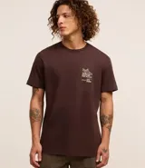 Remera marrón de algodón peruano, corte comfort, cuello redondo, manga corta y estampa frontal con texto y dibujo.