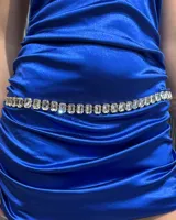 Cinturón de cadena metálica con engarces de cristales rectangulares transparentes, diseñado para usar a la cadera.