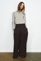 Pantalón de tiro medio con diseño de pierna ancha y estampado de cuadros pequeños. Presenta pinzas frontales, trabillas en la cintura, bolsillos laterales ocultos y cierre frontal con cremallera, botón y ganchos metálicos.