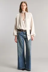 Pantalón de jean tiro medio, wide leg y extra largo, confeccionado en tejido liviano 100% algodón de tono mid blue con sutil localizado.