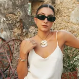 Brazalete rígido abierto de metal color plateado con textura irregular.