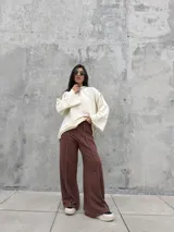 Buzo oversize de color crudo con diseño de costuras expuestas en contraste y terminaciones desflecadas en mangas y ruedo. Presenta un corte holgado con mangas anchas.
