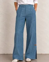 Pantalón de denim azul oscuro con cintura elástica y cordón ajustable, bolsillos frontales aplicados y corte recto.