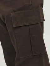 Pantalón cargo marrón de corte relajado, con cierre de gancho y cremallera, bolsillos traseros, frontales y laterales, tiro medio y detalle de cordones en los dobladillos.