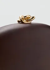 Bolso clutch rígido de madera color marrón, de forma ovalada, con cierre superior metálico dorado con detalle de nudo y forro interior de poliéster.