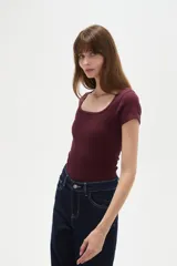 Body de manga corta al cuerpo, color blanco, con cuello redondo y cierre inferior con broches.