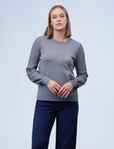 Buzo tejido en hilado fino, color gris, con cuello redondo y mangas largas plisadas.