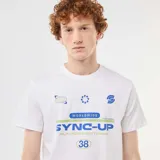 Remera blanca de manga corta y cuello redondo con diseño estampado frontal en tonos azules y verdes con gráficos y texto.