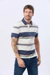 Remera polo de manga corta con cuello y puños en azul oscuro. Presenta un diseño de rayas horizontales en tonos de azul claro, azul oscuro, blanco, amarillo, rosa y verde. Incluye botones personalizados y un logo bordado en el pecho.