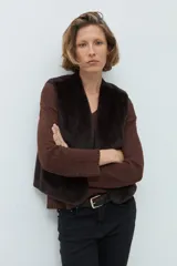 Chaleco reversible de corte recto, con un lado de cuero sintético color chocolate y el otro lado de piel sintética al tono. Presenta cuello redondo y diseño sin mangas.
