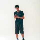 Bermuda negra confeccionada en nylon liviano, con cintura elastizada con cordón, bolsillos laterales y bolsillos cargo de perfil limpio.