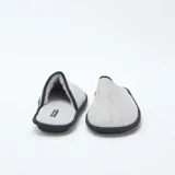 Pantuflas cerradas de tela gris con ribete negro.