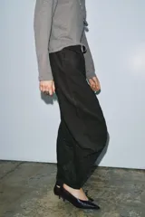 Pantalón de tiro medio con corte wide leg y diseño de rayas verticales a contraste. Cuenta con cintura con trabillas, cierre frontal con cremallera y botón, y cinco bolsillos.