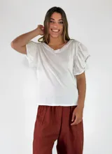 Remera de algodón color blanco, con cuello en V y mangas cortas con volados.