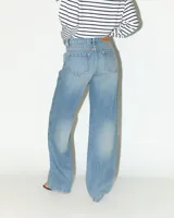 Jeans de tiro medio con corte recto desde la cadera hasta el bajo, de color celeste claro. Diseño clásico de cinco bolsillos con cierre de cremallera y botón metálico.