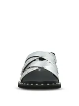 Sandalias de cuero plateado con textura de reptil, diseño de tiras cruzadas decoradas con tachas metálicas. Poseen ajuste mediante hebilla lateral y suela de goma con detalle de tachas en el borde.