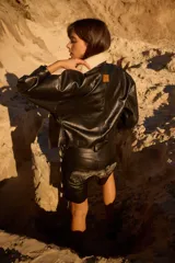 Campera de cuero oversize con solapa amplia de corderito, mangas anchas y detalle de cuero trenzado en la parte delantera.