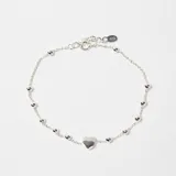 Pulsera de plata 925 con cadena de eslabones finos, decorada con pequeñas esferas metálicas intercaladas y un dije central en forma de corazón.