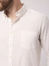 Camisa celeste de lino, de manga larga, con cuello abotonado y bolsillo en el pecho.