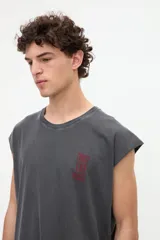 Musculosa gris oscuro con efecto lavado, corte relaxed y estampa en la espalda con la frase "Beyond the noise find your signal" en tono bordó.