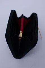 Billetera marrón tipo sobre con cierre de cremallera, confeccionada en cuero con textura tipo cocodrilo y forro textil rojo. Cuenta con múltiples ranuras para tarjetas, documentos y billetes.