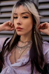 Collar plateado de cadena gruesa con dijes de cruces plateadas, algunas con strass.