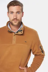 Buzo térmico de polar en color azul marino, con cuello alto y cierre frontal parcial mediante broches. Presenta bolsillos laterales con cierre y un bolsillo adicional con cierre en la manga izquierda.