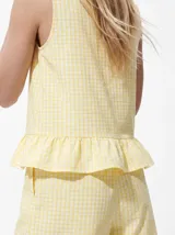 Top sin mangas de algodón orgánico y poliéster reciclado, color amarillo con estampado de cuadros vichy, cuello redondo y detalle de volado en el ruedo.