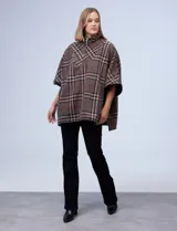 Poncho de tejido soft, marca Weatherproof, con diseño a cuadros en tonos azul marino, beige y celeste. Posee cuello alto con cierre metálico y bolsillos delanteros.