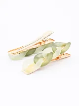 Set de dos broches para el cabello, tipo pinza, con eslabones grandes de acrílico en tonos rosados y blancos jaspeados, con base metálica dorada.