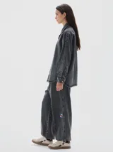 Camisa de denim de corte recto y estilo clásico, confeccionada en tejido de algodón con acabado lavado. Presenta cuello camisero, cierre frontal con botones metálicos y mangas largas con puños abotonados.