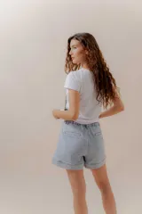 Short de jean celeste, estilo slouchy, tiro medio-alto, con pinzas frontales y dobladillo ancho.