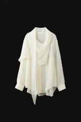 Camisa de mujer confeccionada en mezcla de lyocell, con diseño fluido y cuello tipo pañuelo integrado. Presenta manga larga con puños, bajo redondeado asimétrico y cierre frontal con botones ocultos bajo solapa.