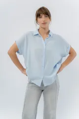 Camisa amplia de manga corta color amarillo, con cuello clásico y botones al frente.