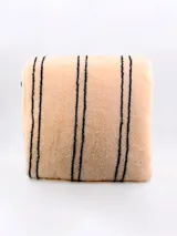 Acolchado de dos plazas color beige con rayas verticales negras.