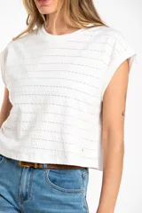 Remera blanca de algodón con textura de puntos calados horizontales, corte al cuerpo y mangas cortas tipo mariposa.