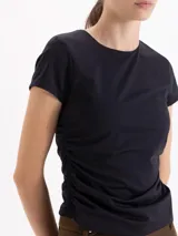 Top de algodón color negro, con cuello redondo, mangas cortas y diseño con frunces laterales que generan un efecto drapeado.
