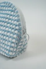 Neceser pequeño con textura de puntos en relieve color rosa y blanco, con cierre superior de cremallera rosa.