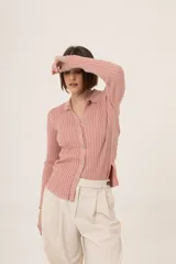 Camisa de punto color rosado, con cuello polo, mangas largas y cierre frontal con botones.