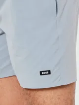 Short de baño Boss color celeste con cintura elástica ajustable mediante cordón, bolsillos laterales y etiqueta con logo de la marca en la parte inferior.