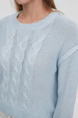 Sweater de punto color celeste, con diseño de trenzas frontales, cuello redondo y corte holgado.