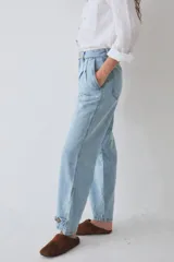Pantalón tipo bombacha de campo confeccionado en denim azul. Presenta pinzas frontales, cierre de botones en los tobillos para ajustar la silueta y costuras reforzadas.