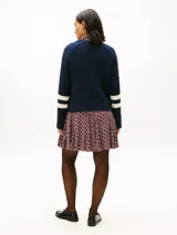 Sweater de punto trenzado Tommy Hilfiger color azul marino, de manga larga y cuello redondo. Presenta un gran logo gráfico bordado en el pecho y bandas blancas en las mangas.