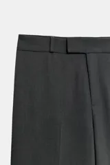 Pantalón de corte recto y tiro medio, confeccionado en tejido con viscosa. Presenta cintura con trabillas, cierre frontal con cremallera, botón interior y ganchos metálicos ocultos.