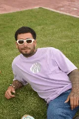 Remera lila con cuello redondo y estampado circular en el pecho con diseño abstracto en tonos grises.