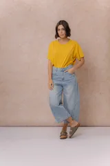 Pantalón de jean estilo barrel con tiro alto y pierna amplia de diseño curvo. Presenta un lavado celeste claro con efecto desgastado, cierre y botón frontal, y bolsillos funcionales.